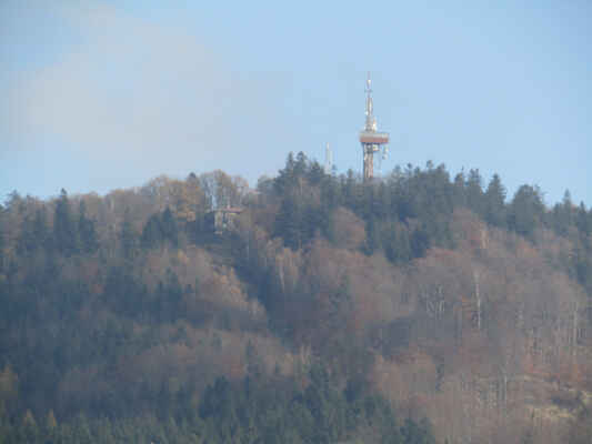 a o dva kopce vpravo je rozhledna Koráb - Dnešní ocelová, 50 metrů vysoká věž, pochází z roku 1992. Na jejím místě stála až do poloviny 80. let 20. století dřevěná konstrukce o výšce 21 m. Z plošiny ve výšce 29 m se návštěvníci mohou těšit z pohledu na Domažlicko a vzdálenější Šumavu, Český les i Brdy. Za dobré viditelnosti je možné spatřit Alpy.