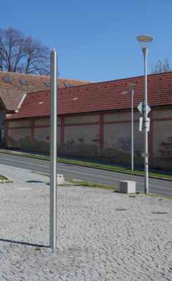 Součástí památníku je také umělecké dílo vytvořené autorem, který si nepřál být jmenován, ale dle všeho je jím sochař David Černý. "TO" je ten sloup na fotce vlevo. Vpravo jsou pouliční lampy.